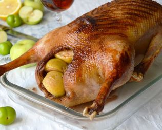 Запеченный гусь с яблоками и алычой в духовке